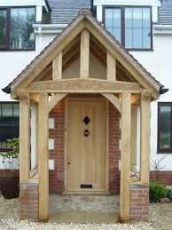 the front entrance to a house with a wooden door and brick pillars on either side