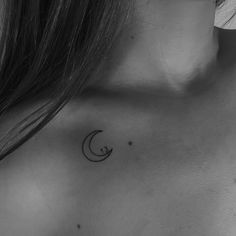 a black and white photo of a woman's chest with a crescent tattoo on it