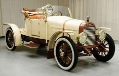 an old model car is parked in a garage