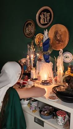 a person reaching for food on a counter in a room with plates and other items