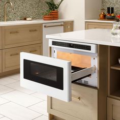 an open oven door in a kitchen with wooden cabinets and white counter tops, on the floor