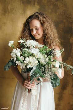 a woman holding a bouquet of white flowers