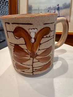 a coffee cup with designs on it sitting on a table