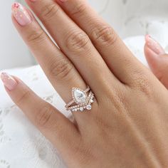 a woman's hand with two wedding rings on top of her finger and the other half