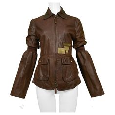 Resurrection is excited to offer a vintage Gianfranco Ferre brown leather aviator jacket featuring two front flap pockets, a two-way center-front zipper with leather pulls, brass hardware, buttons, signature plaques, and striped bands above the elbows and across the back waist. Gianfranco Ferre Size 40 Leather Exterior with Lined Interior Excellent Vintage Condition Authenticity Guaranteed Hardware Buttons, Leather Aviator Jacket, Comme Des Garcons Black, Aviator Jacket, Gianfranco Ferre, Aviator Jackets, Fire Fits, Junya Watanabe, 1940s Fashion