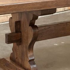 a wooden bench sitting on top of a cement floor