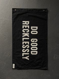 a black and white sign hanging on the side of a wall that says recklessly