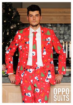 a man in a red christmas suit standing next to a counter