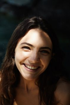 a woman smiling and looking at the camera