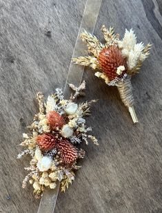 two dried flowers sitting on top of a piece of clear acrylic paper next to each other