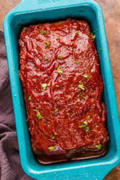 meatloaf in a blue casserole dish with parsley on the side