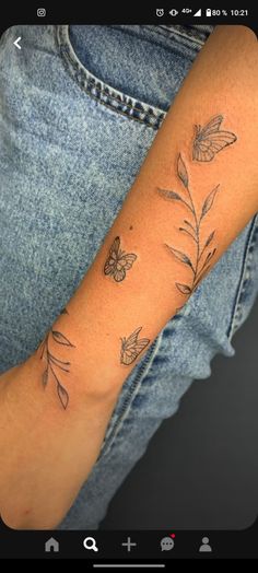 a woman's arm with butterflies on it and leaves in the middle of her arm