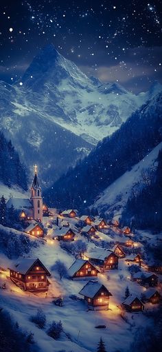 a snowy mountain village at night with lights on the houses and mountains in the background