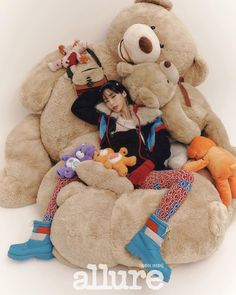 there is a large teddy bear sitting on top of a pile of other stuffed animals