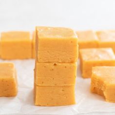 several pieces of yellow fudge sitting on top of white paper next to each other