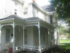 an old white house with porches and columns