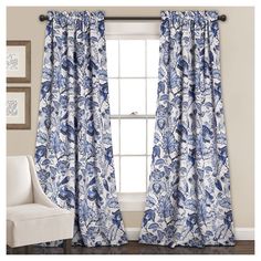 a blue and white floral curtain hanging in front of a window next to a chair