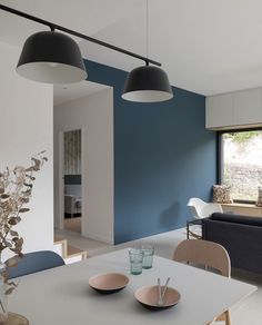 a dining room table with two plates on it next to a blue couch and window