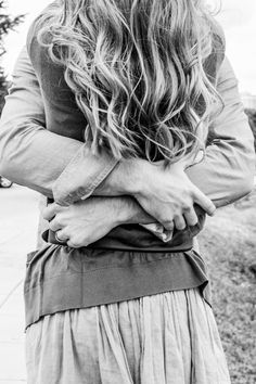 black and white photo of woman with long hair holding her hand on her hip while walking down the street