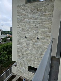 a brick wall on the side of a building next to a metal hand rail and railing