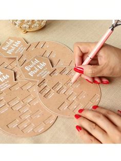 a woman is writing on a piece of cardboard