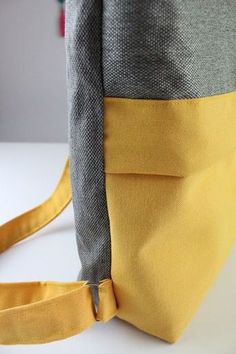 a yellow and grey bag sitting on top of a white table