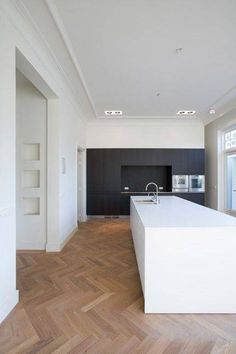 an iphone photo of a kitchen and living room in a house with wood flooring