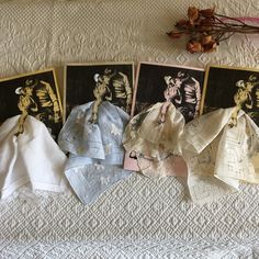 five handkerchiefs laid out on a bed with flowers in the corner and pictures hanging above them