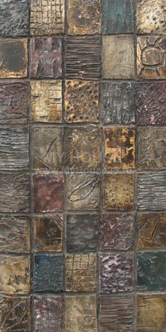 a close up view of a tile wall with many different colors and patterns on it