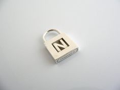 Does the letter "N" have a special significance for you? You're in luck! You just found a wonderful Tiffany piece for yourself or that special person! Offered for sale is a wonderful Tiffany & Co. Sterling Silver Alphabet "N" padlock pendant / charm.  The padlock opens and closes.  Super versatile charm that you can add on to any necklace or bracelet ... Perfect item to show off your "Tiffany" style!   The piece is simple, elegant, and classic all rolled into one item.  It is a wonderful T Tiffany And Co Padlock Necklace, Alphabet N, The Letter N, Ring Size Adjuster, Victoria Kay, Tiffany And Co Necklace, Alphabet Necklace, Precious Rings, Gorgeous Engagement Ring