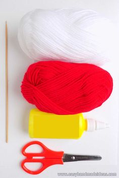 yarn, crochet hooks and knitting needles on a white surface