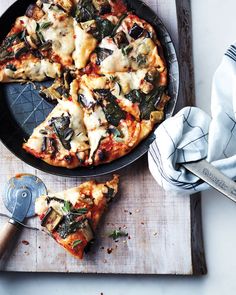 a pizza sitting on top of a pan covered in cheese and toppings next to a spatula