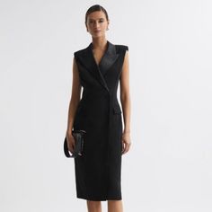 The Black Amari Dress Nods Toward Traditional Menswear Tailoring With Its Confident Double-Breasted Shape, Padded Shoulders, And Four-Button Fastening. It S Given A Feminine Twist With Satin Lapels And A Chic Midi Length, Which Wraps Close Against The Frame. Style Tonally For A Timeless Look. Wrap Design. Double Breasted. Satin Peak Lapels. Padded Shoulders. Sleeveless. Four-Button Fastening. Flap Pockets. Midi Length. Fitted. Lined. The Model Is Wearing A Size 8. Measurements Of Model: Height 5ft 10'' / 178cm. Regular Side Neck To Hem 45.5" / 115cm. Tailored Black V-neck Dress, Chic V-neck Jacket Dress For Formal Occasions, Tailored Elegant Jacket Dress For Party, Elegant Tailored Jacket Dress For Party, Chic Fitted Cocktail Jacket Dress, Chic Fitted Jacket Dress For Cocktail, Elegant V-neck Jacket Dress For Formal Events, Fitted Structured Formal Dresses, Formal Fitted Structured Dress