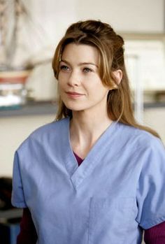 a woman in scrubs is smiling at the camera