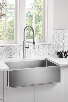 a stainless steel sink in a white kitchen