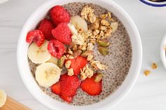 a bowl of oatmeal with fruit and granola in it on a table