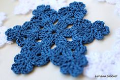 crocheted blue and white snowflakes on a table