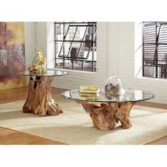 a glass table sitting on top of a rug next to a wooden tree stump in front of a window