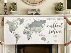 two people holding up a world map poster in front of a fireplace with the words, harrison gibson is called to serve in the usa