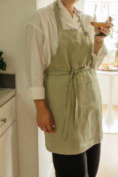 a woman in an apron holding a wine glass