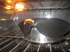 an oven with some food cooking in it and light on the inside of the oven