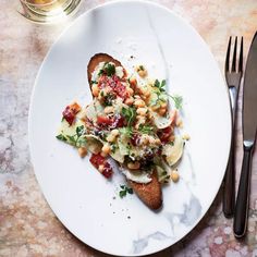 a white plate topped with food next to silverware