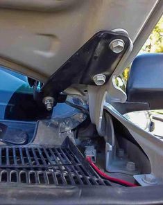 the inside of a car with its hood open and it's battery still attached