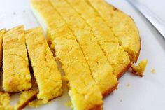 two pieces of cornbread sitting on top of a white plate next to each other