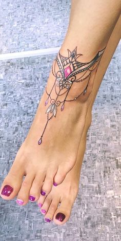 a woman's foot with a tattoo on it and pink nail polishes in the middle