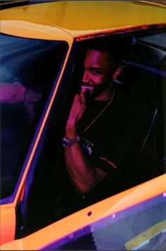 a man sitting in the driver's seat of a car talking on his cell phone