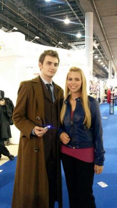 a man and woman standing next to each other in front of a blue carpeted floor