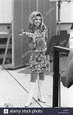 an old black and white photo of a woman singing in front of a microphone - stock image