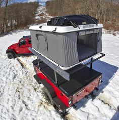 a truck with a trailer attached to it in the snow