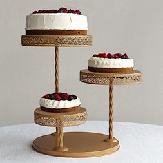 three tiered cake stand with white frosting and berries on top